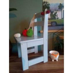 Grijs houten kinderstoeltje.