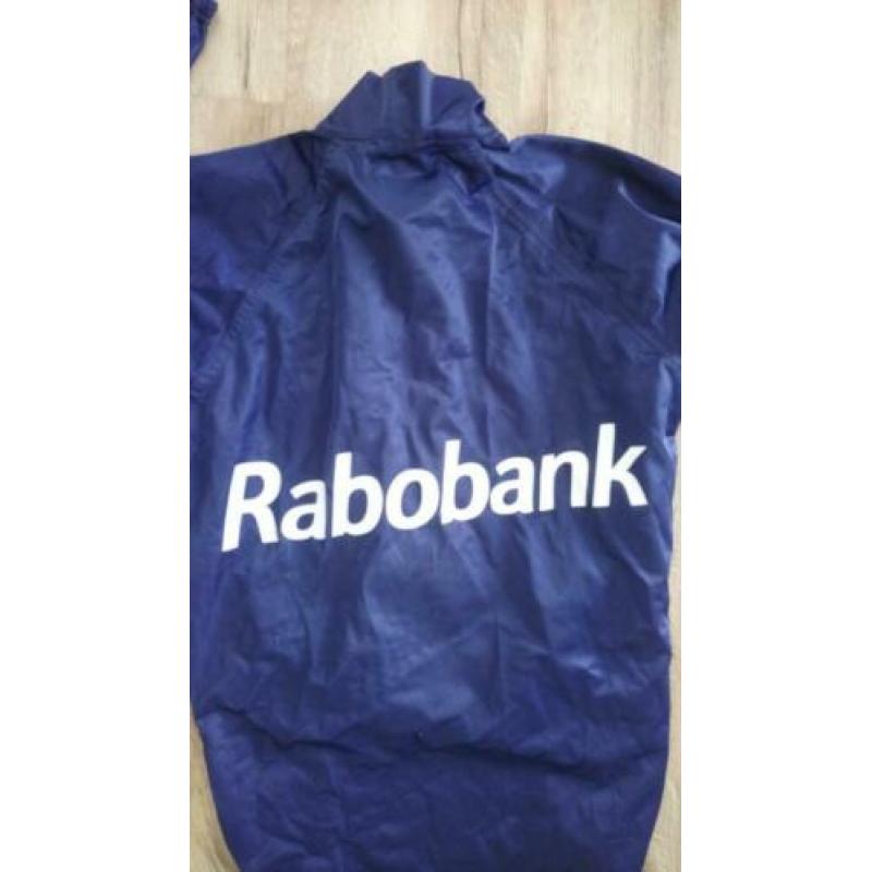Mooie blauwe AGU Rabobank fietsjas, maat M. Regenjas AGU.